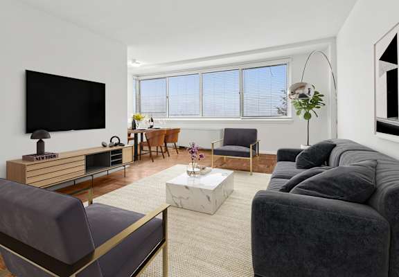 A living room with a grey couch, a wooden entertainment center, and a flat screen TV.