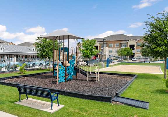 A playground with a slide and two benches.