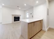 Thumbnail 8 of 23 - Living room with fireplace and kitchen at Avia Lofts at Maple Road, Amherst, NY