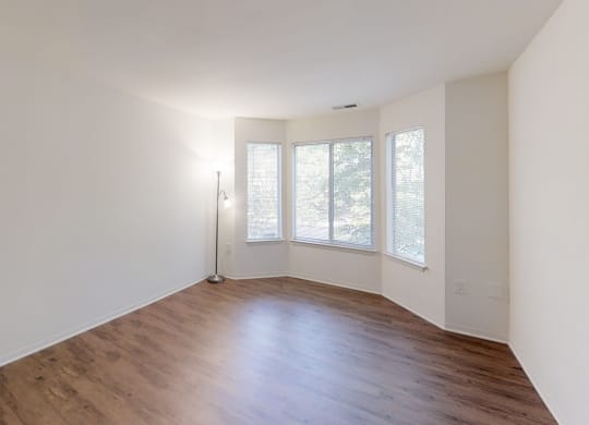 an empty living room with white walls and wood floors