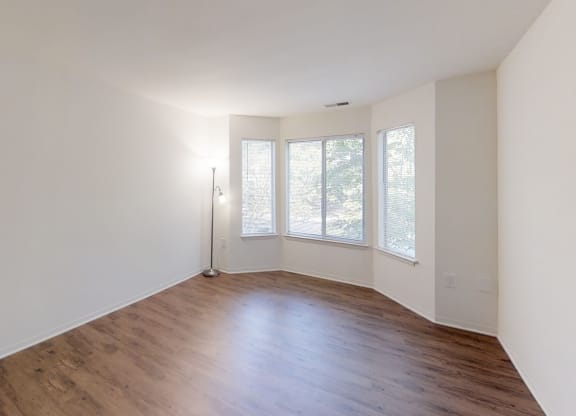 an empty living room with white walls and wood floors