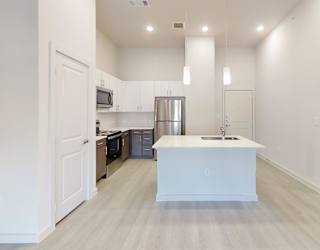 A kitchen with white cabinets and a white island.
