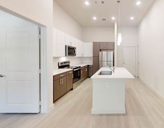 A kitchen with white cabinets and a white island.