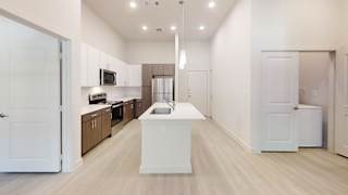 Open concept kitchen with island and vaulted ceiling at Cantarra Apartments, Manor, TX