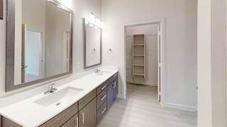 Master bathroom with double vanity and walk-in closet at Cantarra Apartments, Manor, Texas