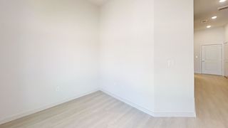 Empty room with light wood flooring and white walls at Cantarra Apartments, Manor, Texas