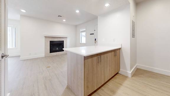 Living room with fireplace and kitchen at Avia Lofts at Maple Road, Amherst, NY