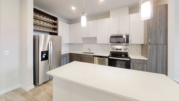 a white kitchen with stainless steel appliances and white counter tops