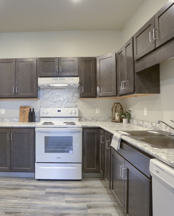 a kitchen with dark cabinets and white appliances