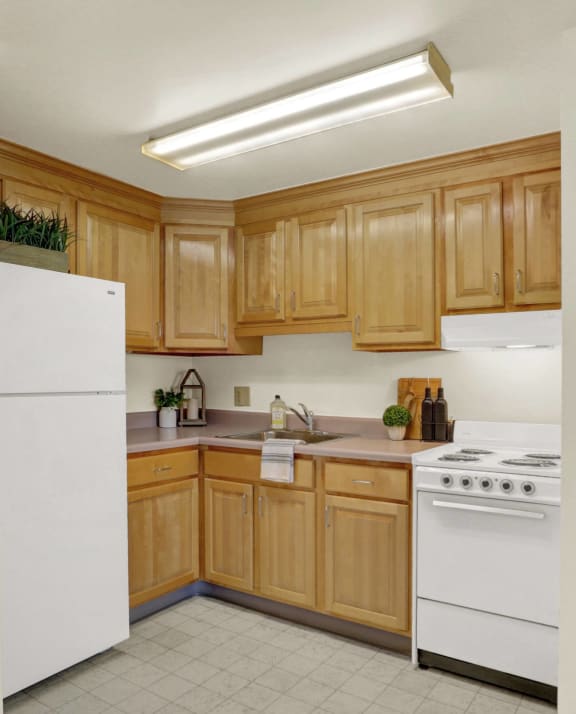a kitchen with white appliances and wooden cabinets | Lancaster House North | Apartments in Lancaster