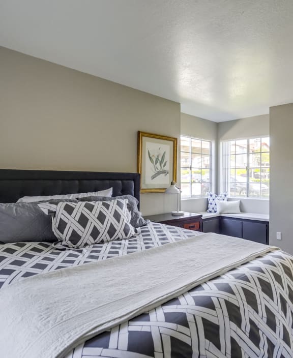a bedroom with a large bed and a desk with a chair at Vista Promenade Apartments, Temecula, California