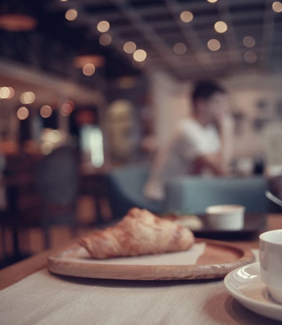 a cup of coffee and a pastry on a table in a restaurant at Arlo Luxury homes Apartments, Little Rock, Arkansas