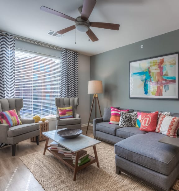 a living room with gray walls and a ceiling fan