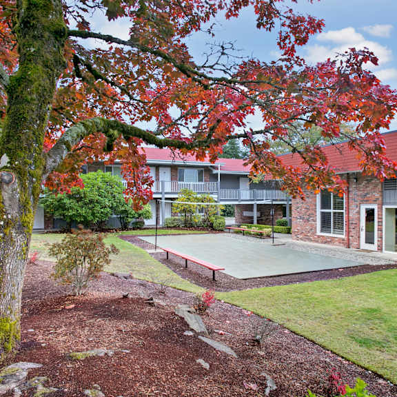 The courtyard at Colonial Square with a tennis court and trees. 