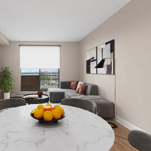 A living room with a grey couch, a round table, and a television.