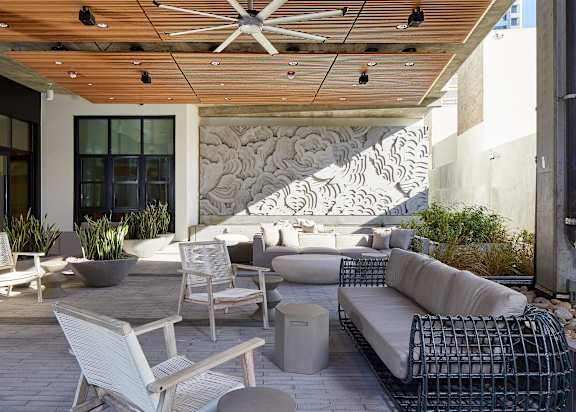 A patio with a white chair and a white couch.