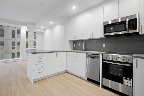 a kitchen with white cabinets and stainless steel appliances