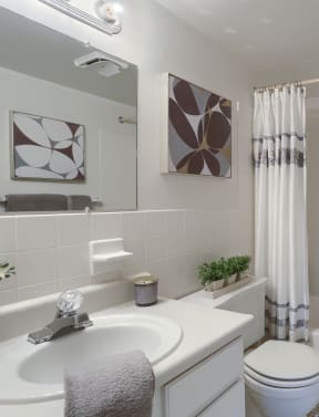 a bathroom with a white sink and toilet next to a white bathtub
