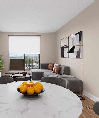 A modern dining room with a round marble table and grey chairs.