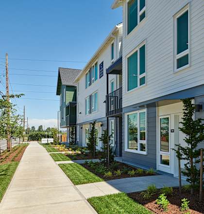 a row of houses on the side of a sidewalk