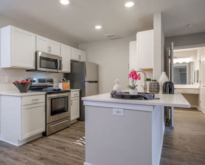 a kitchen with white cabinets and stainless steel appliances at Saw Mill Village apartments