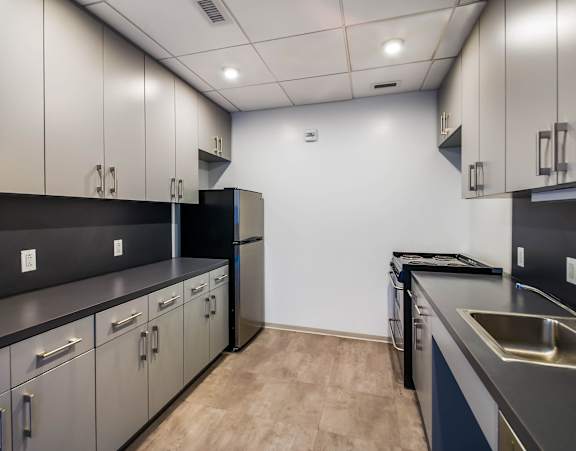a large kitchen with a long island with chairs and a dining table