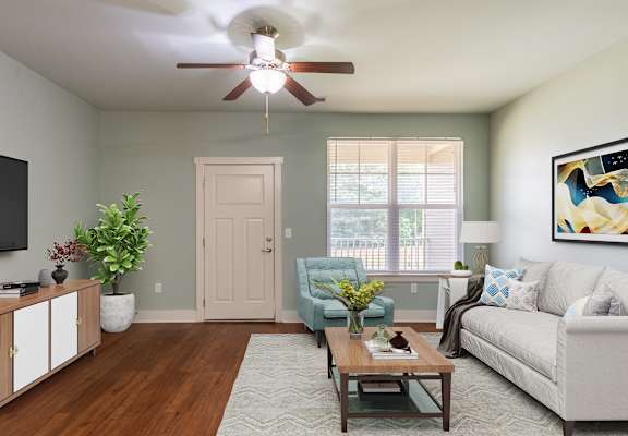A living room with a couch, chair, and potted plant.