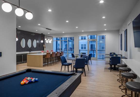a communal area with a pool table and tables and chairs and a bar at 2929 on Mayfair, Wauwatosa, WI, 53222