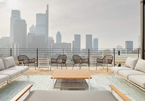 a rooftop patio with a view of a city skyline