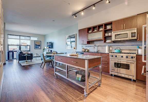 an open kitchen with a island and a living room with a couch