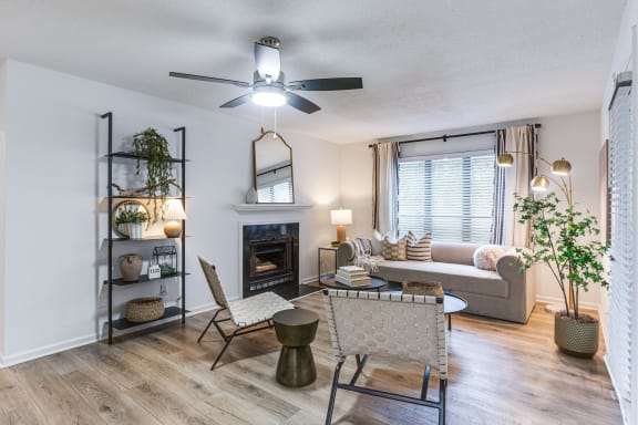 an open living room with a fireplace and a ceiling fan