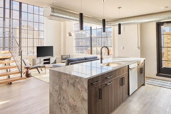 a kitchen with an island and a living room with a couch and a tv