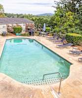 A large outdoor swimming pool surrounded by lounge chairs at Overlook Club Apartments, Cummings