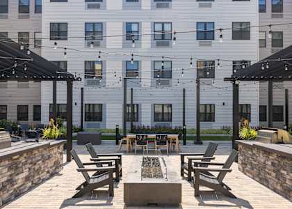 A patio with a table and chairs is in front of a building. at 1010 Apartments, Allentown, 18101