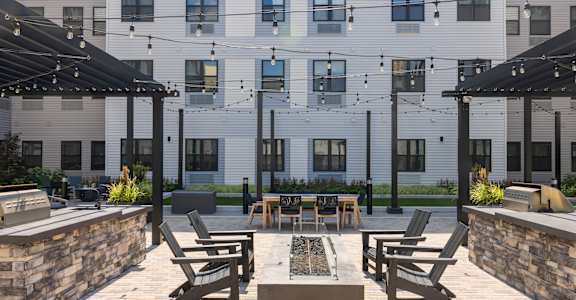 A patio with a table and chairs is in front of a building. at 1010 Apartments, Allentown, 18101