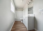 Thumbnail 5 of 8 - A white bathroom with a toilet, sink, and mirror.
