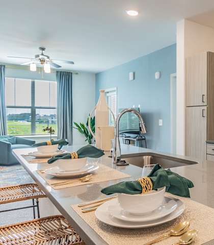 A modern kitchen with a dining table set for two.
