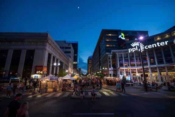 a crowd of people walking down a street in a city at night