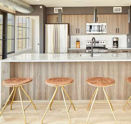 a kitchen with three stools in front of a counter top
