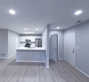 an empty living room and kitchen with white walls and wood flooring at Keita 1875, College Park, 30349