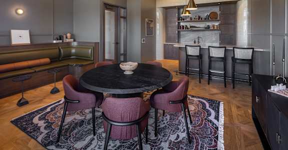 A modern dining room with a round table and chairs.