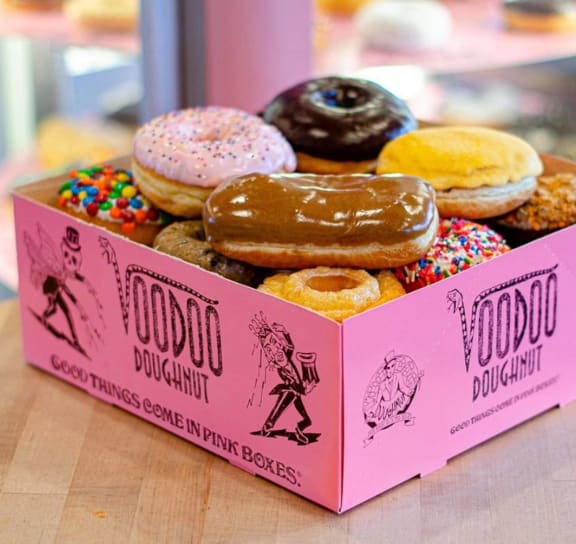 a pink box of doughnuts sitting on a table at AVIA Lofts on Parkway Apartments, Vancouver, 98662