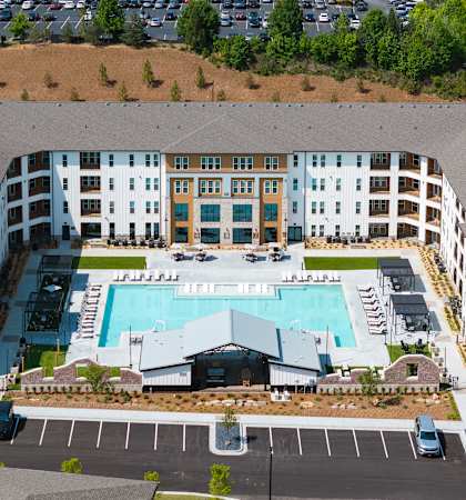 An aerial view of a large building with a pool in the middle.