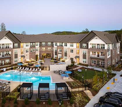 A large building with a pool in front of it.