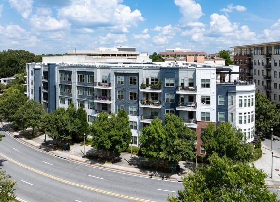 an aerial view of an apartment building with trees and a street