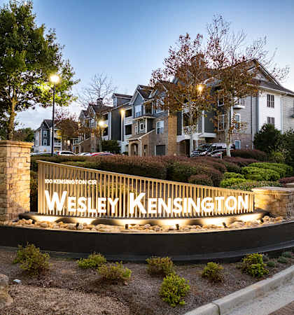A sign that says Wesley Kensington in front of a building.