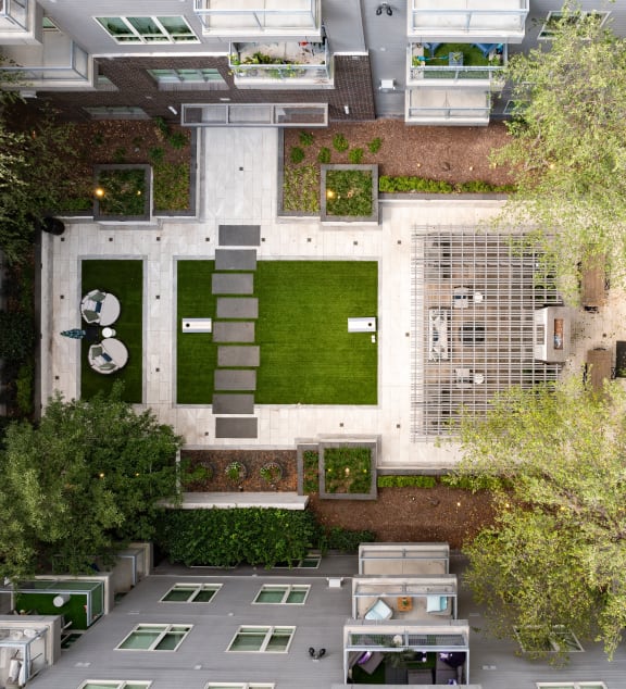 an aerial view of a courtyard in a building with grass and trees