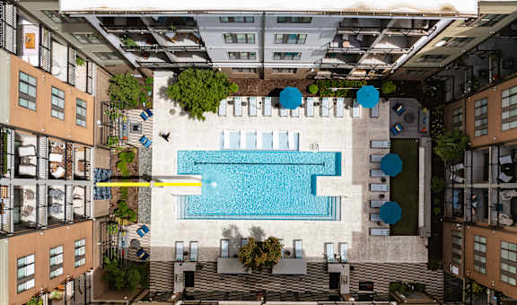 Luxury Apartment Community with Central Pool, Sundeck, and Lounge Seating