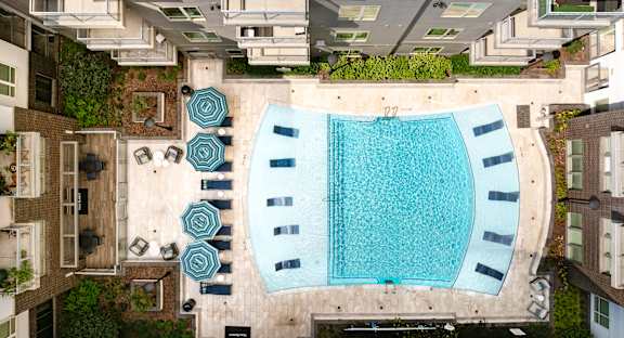 an aerial view of a swimming pool in the middle of apartments