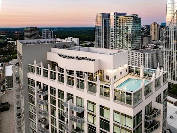 an aerial view of a skyscraper with a pool on the roof of a building